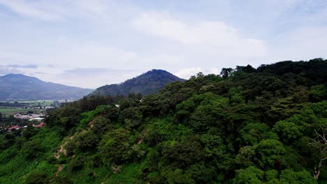 aerial dolly above mountain ridgelines outside of farming village, blue sky day
