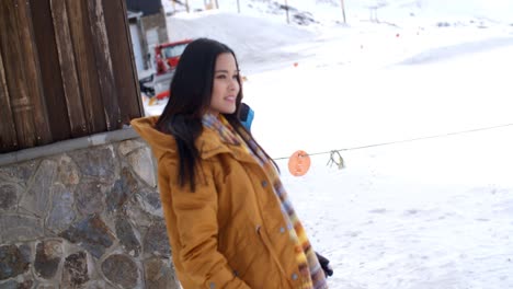 two young women walking through snow at a resort