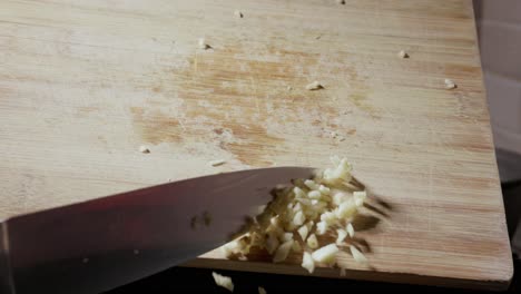 Gehackter-Knoblauch,-Der-Vom-Holzbrett-Fällt