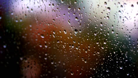 water drops background. rain drops on glass window in rainy season. large raindrops strike on a window frame. close-up.