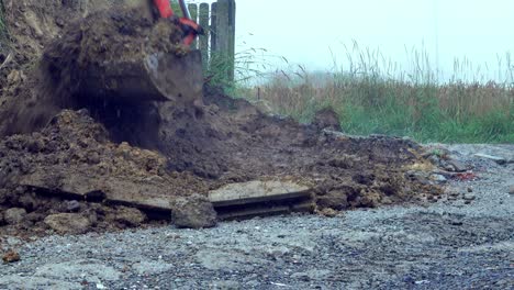 precise excavator as it digging a trench for water pipes in a private property, working meticulously alongside a fence