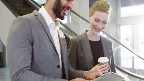 Business-people-discussing-over-digital-tablet