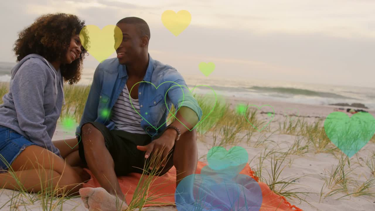 Pair exchanging looks on orange blanket by sea, sharing affection, causing hearts drifting for ads