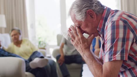 Sad-senior-caucasian-man-crying-at-support-group-meeting-of-senior-friends,-slow-motion