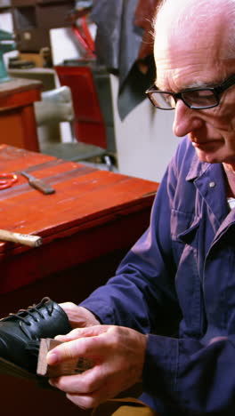 shoemaker polishing a shoe