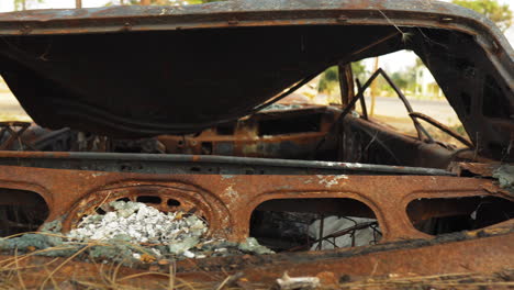 Vista-Detallada-De-Un-Vehículo-Quemado-Corroído-Abandonado-En-El-Paraíso,-Ca