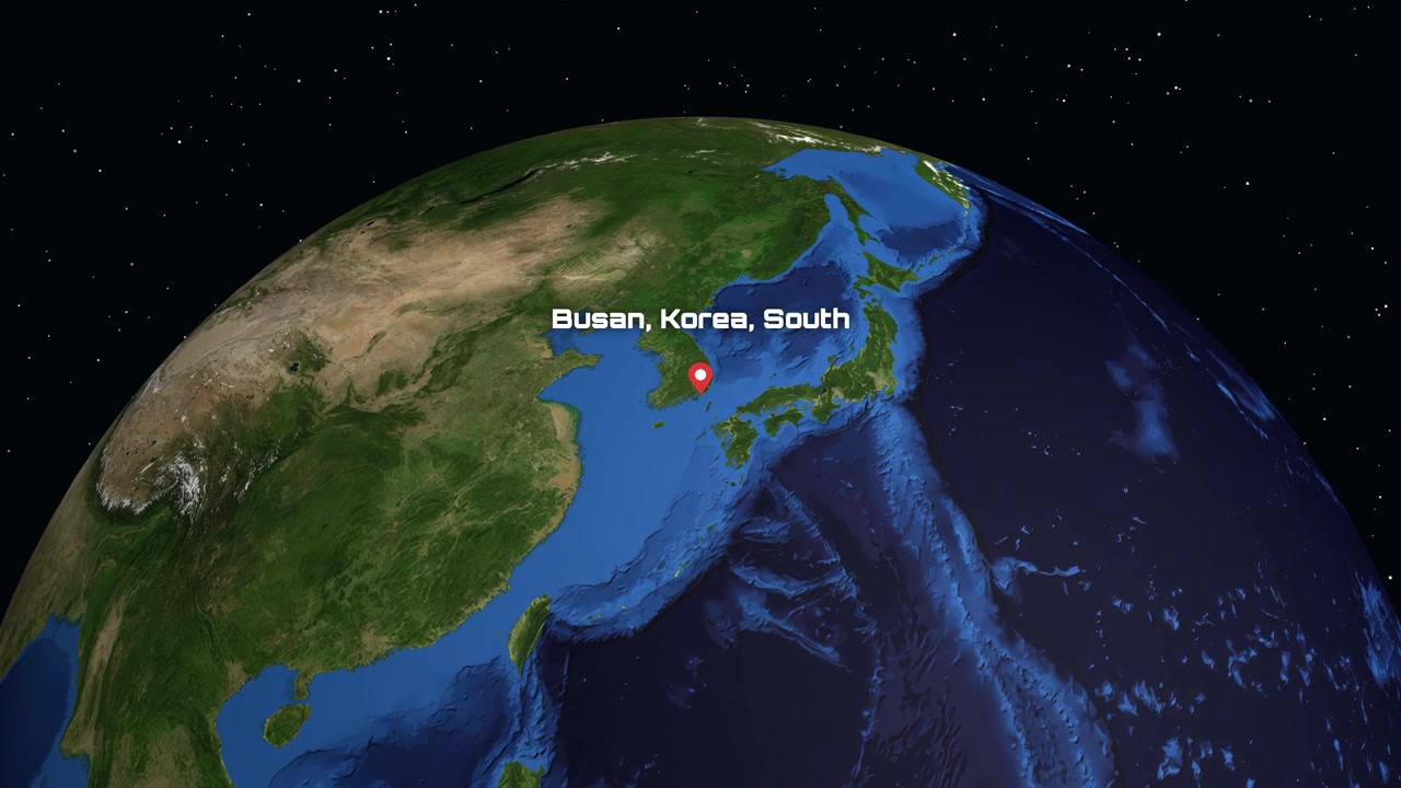 Sebuah animasi digital memperbesar dari luar angkasa ke Bumi, menunjukkan lokasi Busan, Korea Selatan dengan teks.