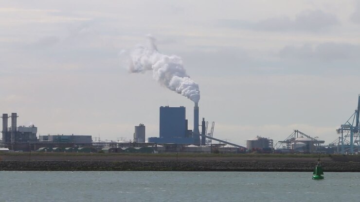 Looking across the water from the Hook of Holland towards factories, chimney and docks etc-1