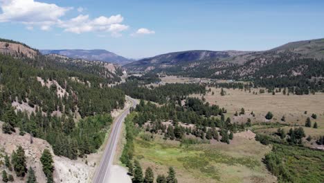 Mountains,-forest-and-a-long-empty-road