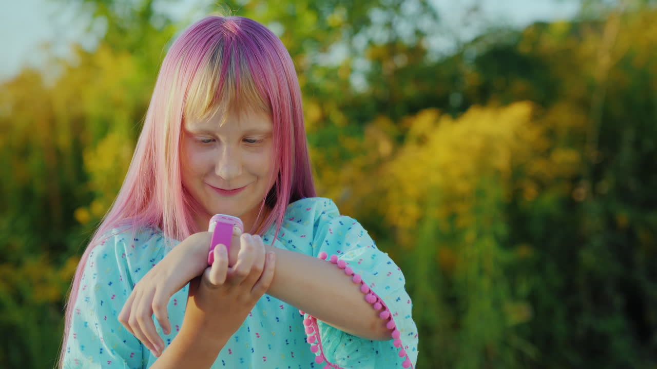 retrato de una chica alegre hablando con un reloj inteligente al aire libre
