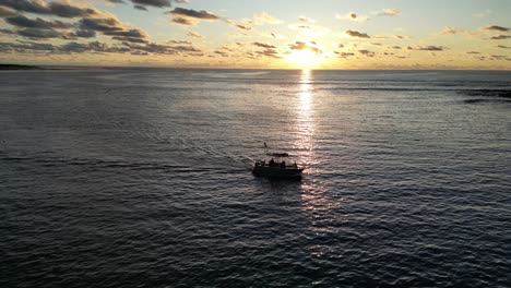 aerial view of tourist boat on sea during golden sun set in margaret river, western australia