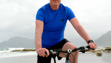 front view of old caucasian man riding bicycle at beach 4k