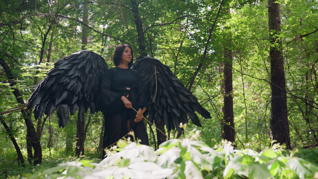 Warrior with black wings stands among plants holding bow as sunlight shines from behind, calm bold expression radiating power and grace, ethereal fantasy moment blending nature