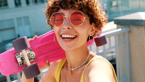 woman with pink skateboard on a rooftop