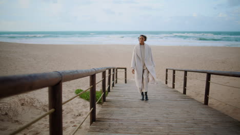 lonely woman walking beach wooden pathway. serene african american enjoy time