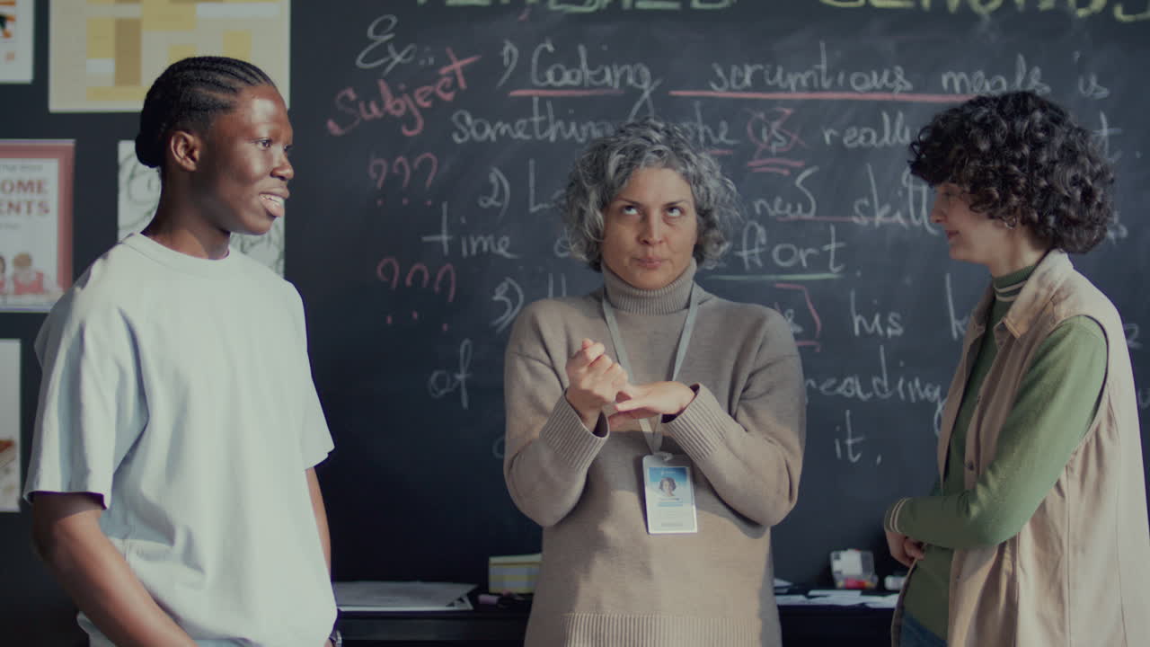 maestro explicando puntos poco claros a los estudiantes jóvenes después de la lección de inglés