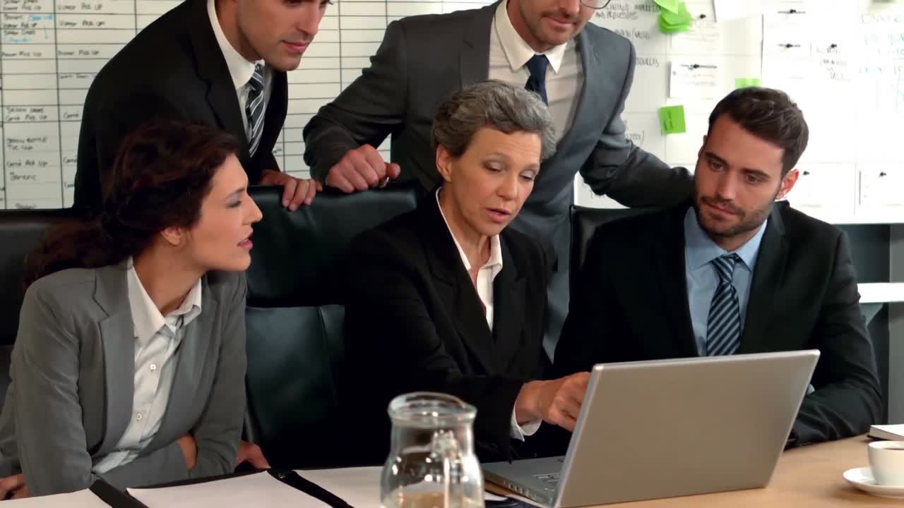 Business people looking at laptop