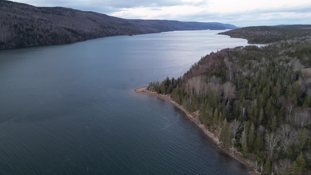 Drone shot of the Bra's D'or Lake with a sandy beach and view of trees