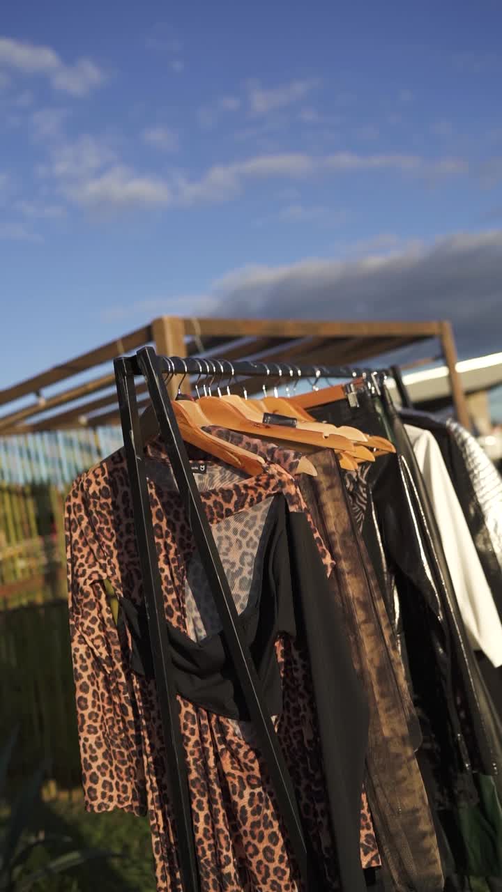 ropa vintage de colores en un estante al aire libre, compras de diferentes estilos de colores, video vertical