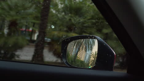 gotas de lluvia en la ventana del coche con vista en el espejo lateral