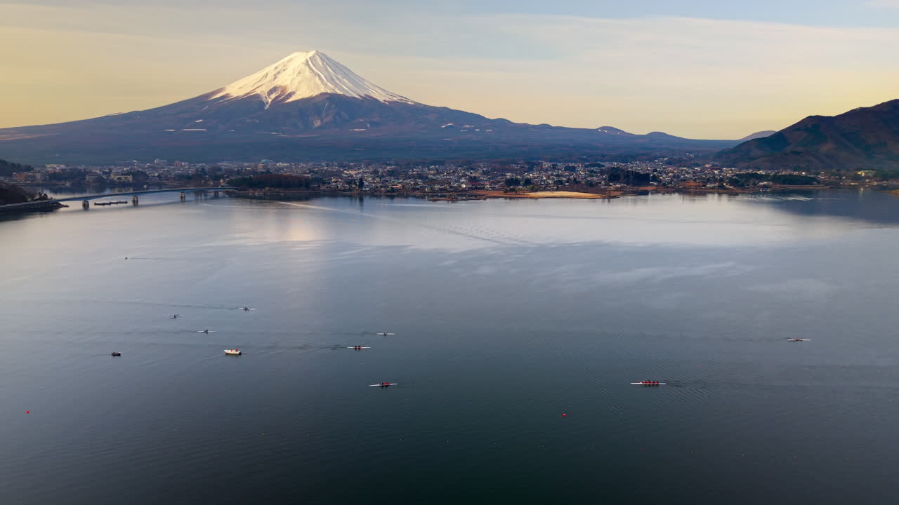 Aerial drone view of rowing boats moving on Lake Kawaguchiko near the Fujikawaguchiko town, Japan with Mount Fuji on the background