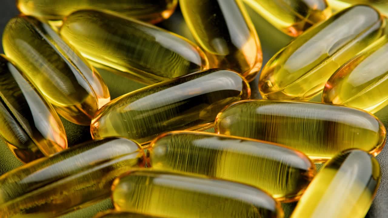 pastillas amarillas transparentes con líquido en el interior girando lentamente, primer plano de cuadro completo