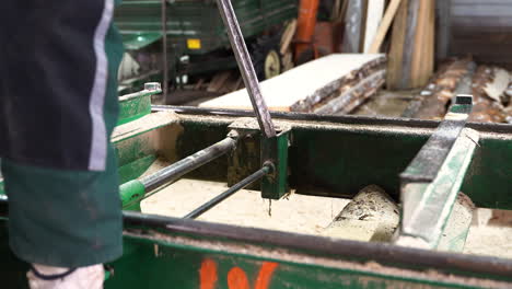 person preparing support for log cutting in sawmill, close up view