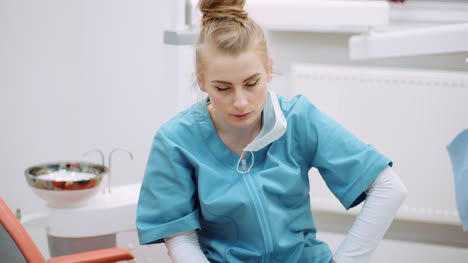 Medium-Shot-Of-Exhausted-Dentist-Sitting-At-Chair-2