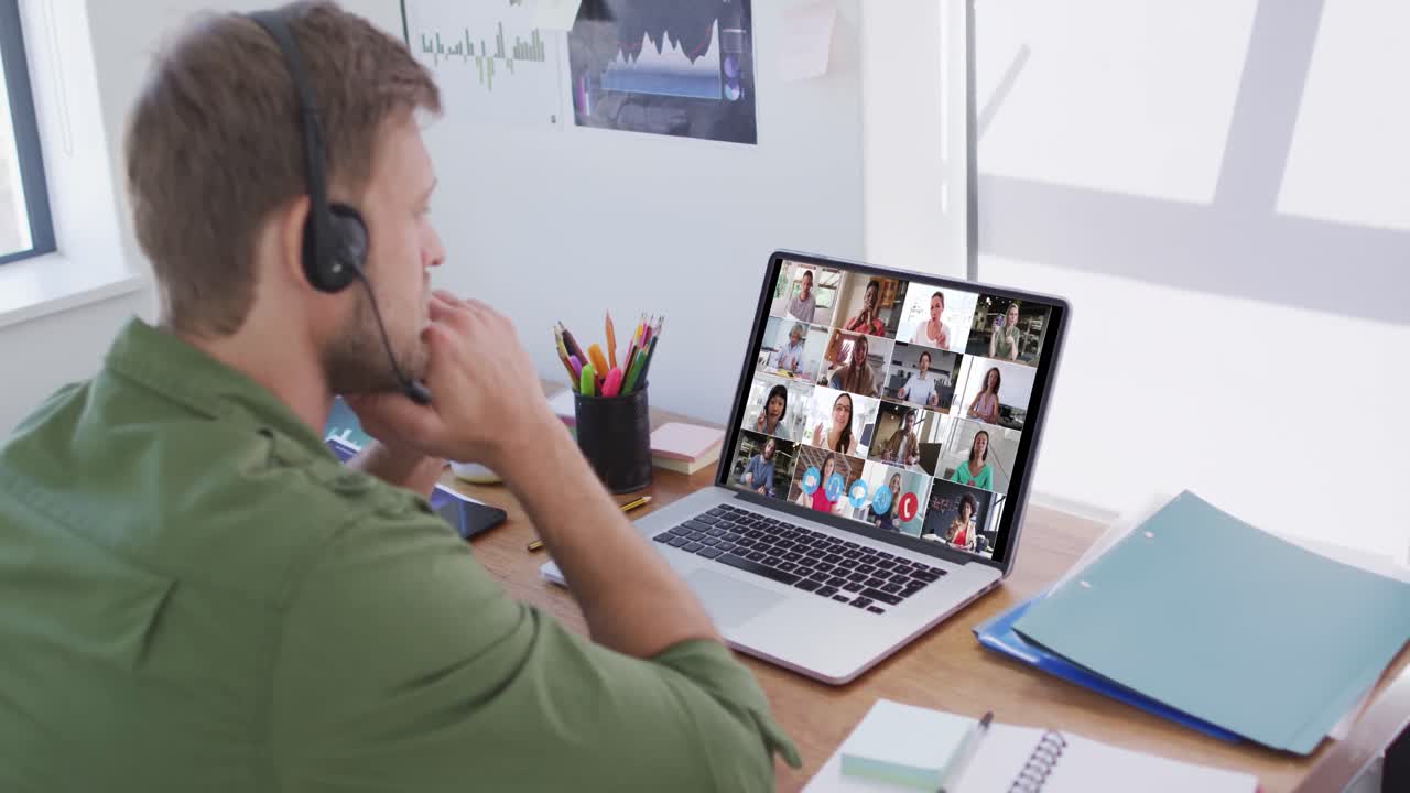 Kaukasisk mand bruger bærbar computer og telefonheadset på videoopkald med kolleger