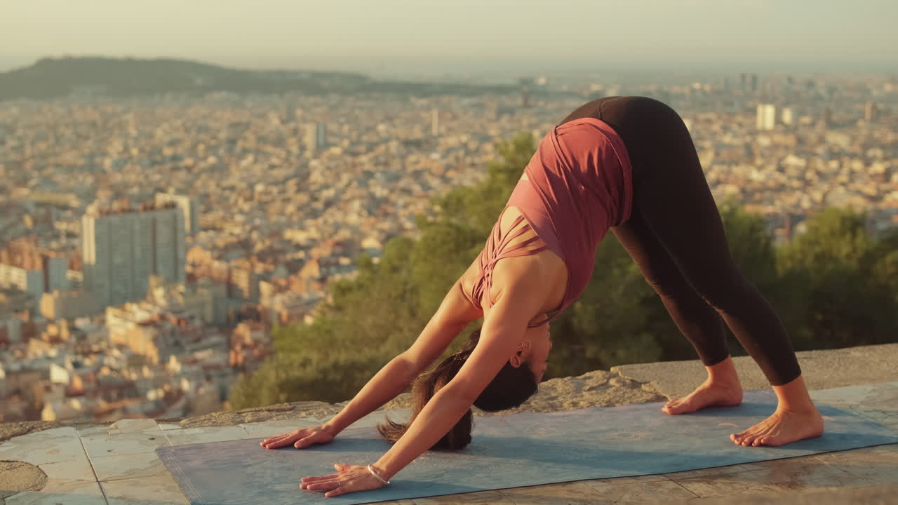 Woman practicing yoga outdoors with city backdrop