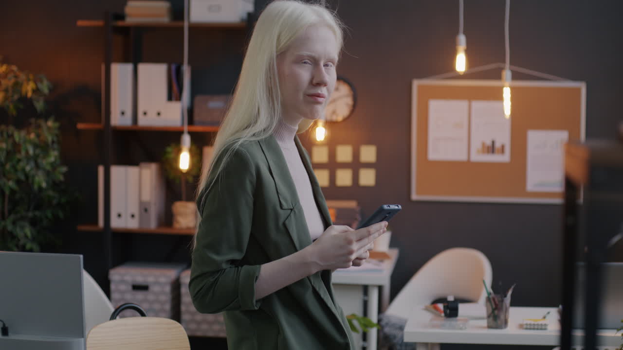 Young Woman in Office Using Smartphone