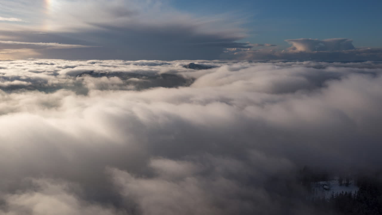 Drone hyperlapse with inversion clouds rolling through the mountains in Bergen, Norway at winter