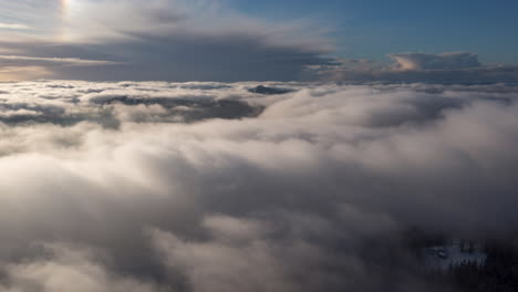 Drone-hyperlapse-with-inversion-clouds-rolling-through-the-mountains-in-Bergen,-Norway-at-winter