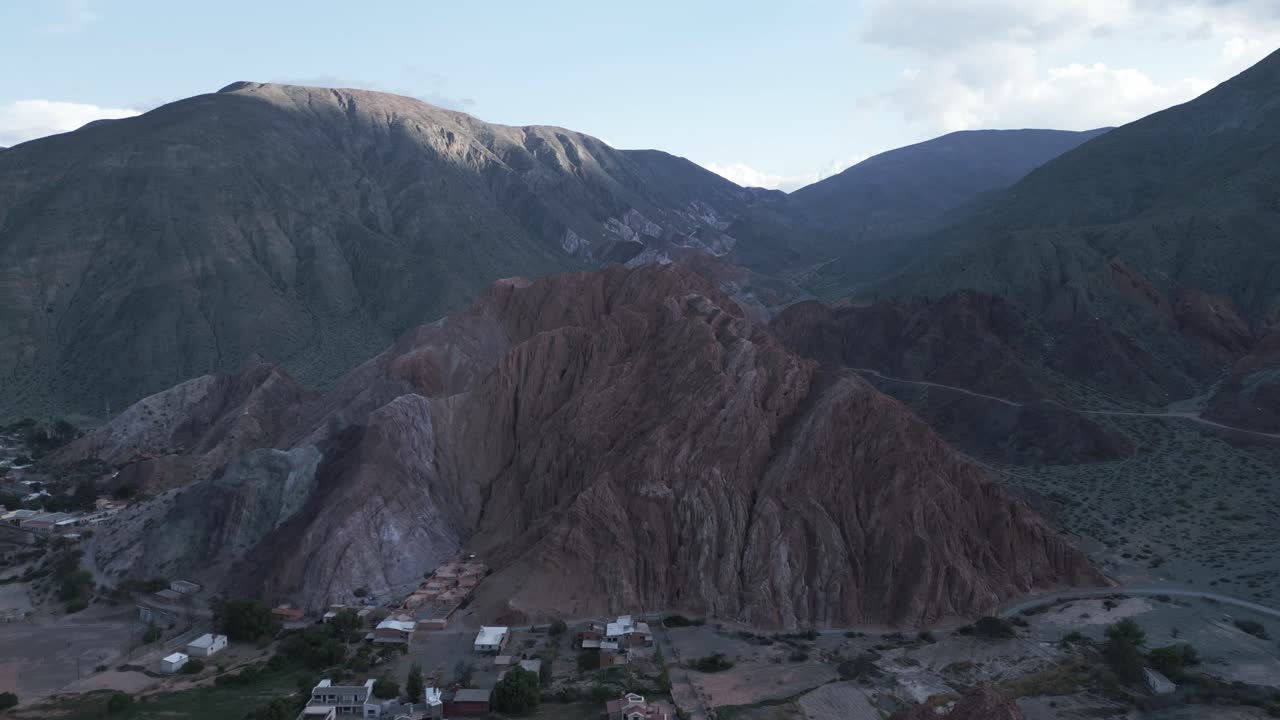 drone aéreo sobre la ciudad de purmamarca, jujuy argentina, colinas de siete colores, montañas escénicas, cielo y cordillera andina, quebrada de humahuaca, destino de viajes y turismo