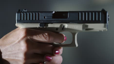 mujer con pistola de transición de dedo al gatillo para apuntar