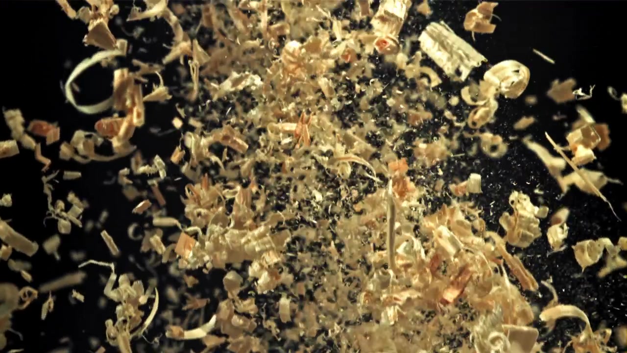 Træspåner og savsmuldspartikler falder i slowmotion