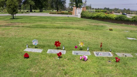 aerial close-up panning shot of headstones with floral decorations at a mortuary in california