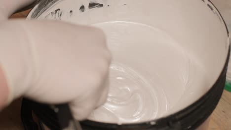 a worker open bucket the paint for painting the walls