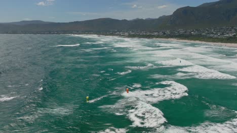kiesurfer tackles large ocean waves off the coast of hermanus, western cape, south africa