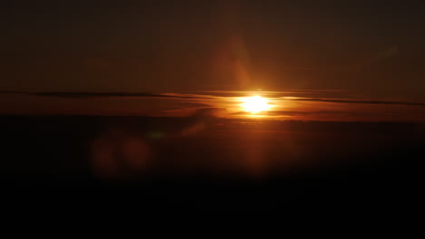 Epic-aerial-shot-of-dazzling-sunlight-at-horizon-during-sunset-in-evening