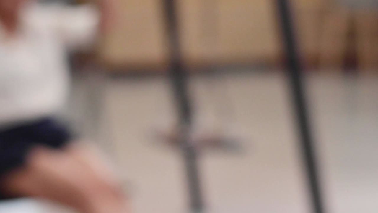 A person in casual attire swings indoors, creating a dynamic and blurred visual effect.