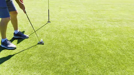 golfista pone la pelota hacia el agujero en el verde