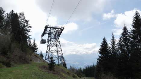 Static-low-angle-shot-of-Nordkette-Cable-Car-system,-gondola-lift-passing-by