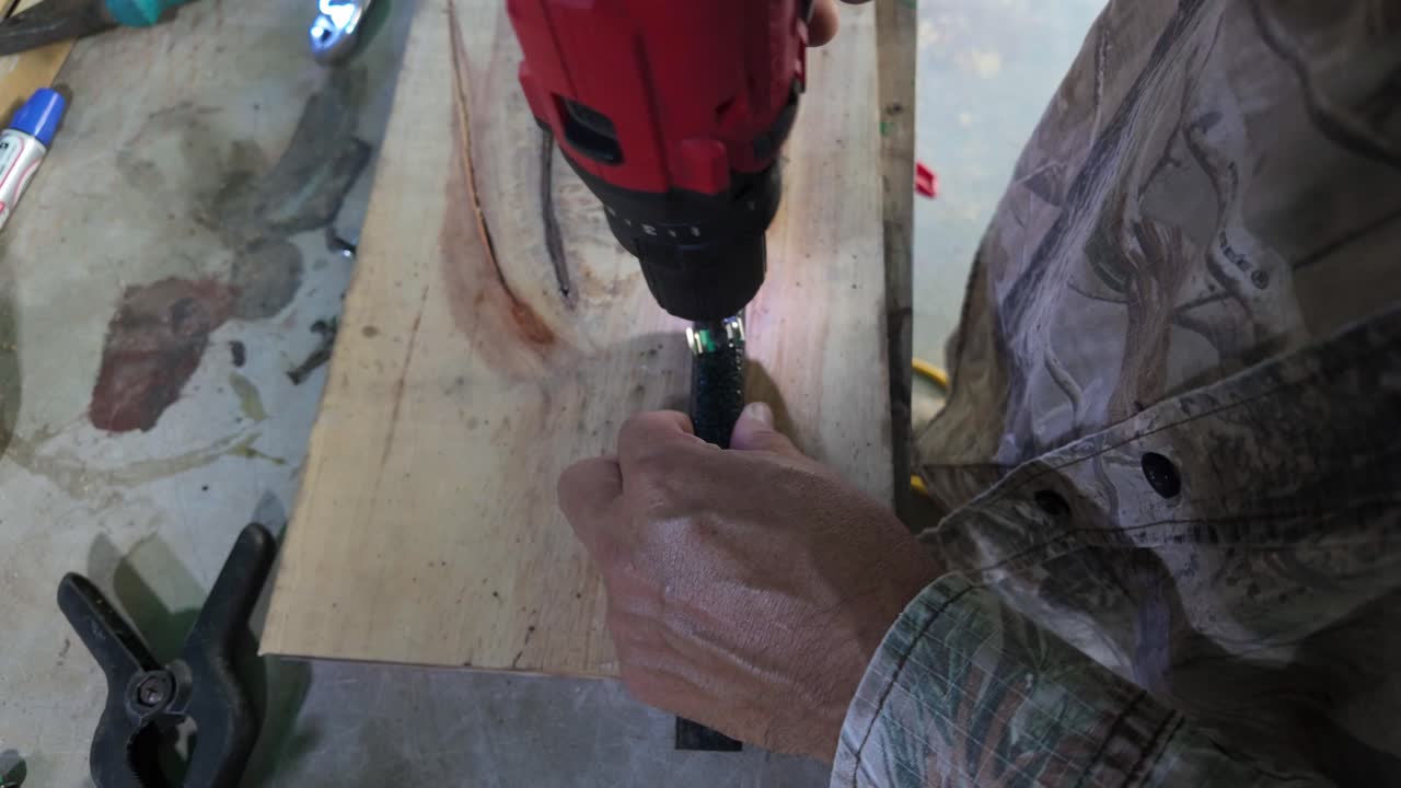 Craftman. Man hands screws nail into metal using cordless drill, close up