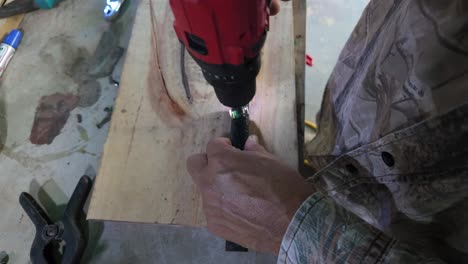craftman. man hands screws nail into metal using cordless drill, close up