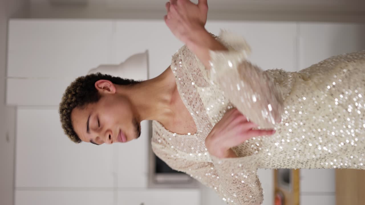 집에서 소파에서 웃긴 옷을 입은 트랜스섹슈얼 남자가 춤을 추고 있습니다.