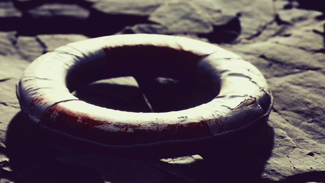 Lifebuoy rests on rocky shore awaiting the next adventure at sunset
