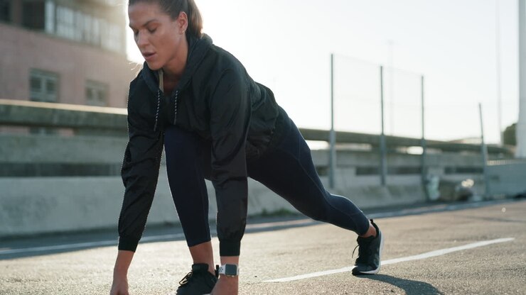 a young woman getting ready to run on an urban