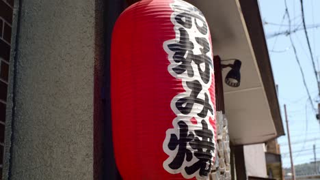 Traditional Japanese lantern sign hanging outside a restaurant in Kyoto, Japan soft lighting slow motion 4K