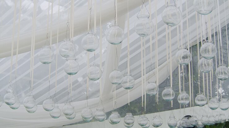 Dozens of glass dome candles hang elegantly from a beautiful white tent, set for a romantic evening at a resort in Antigua, Guatemala